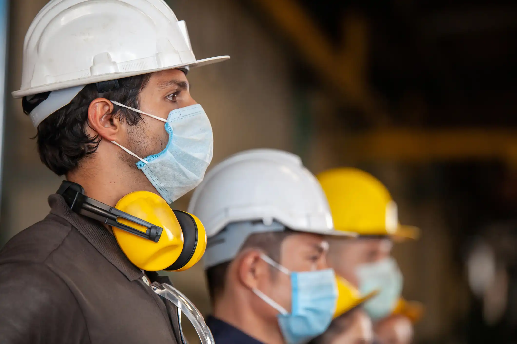 Three male manufacturing workers wearing PPE